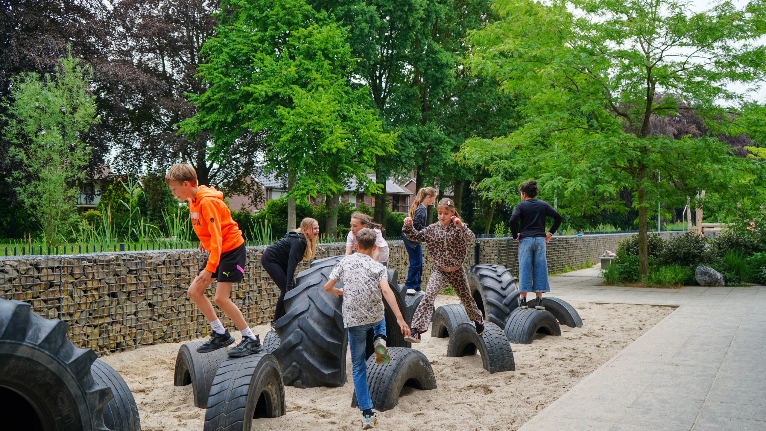Aan de Bron Weert Kinderen spelen samen op oude banden op schoolplein Aan de Bron in Weert