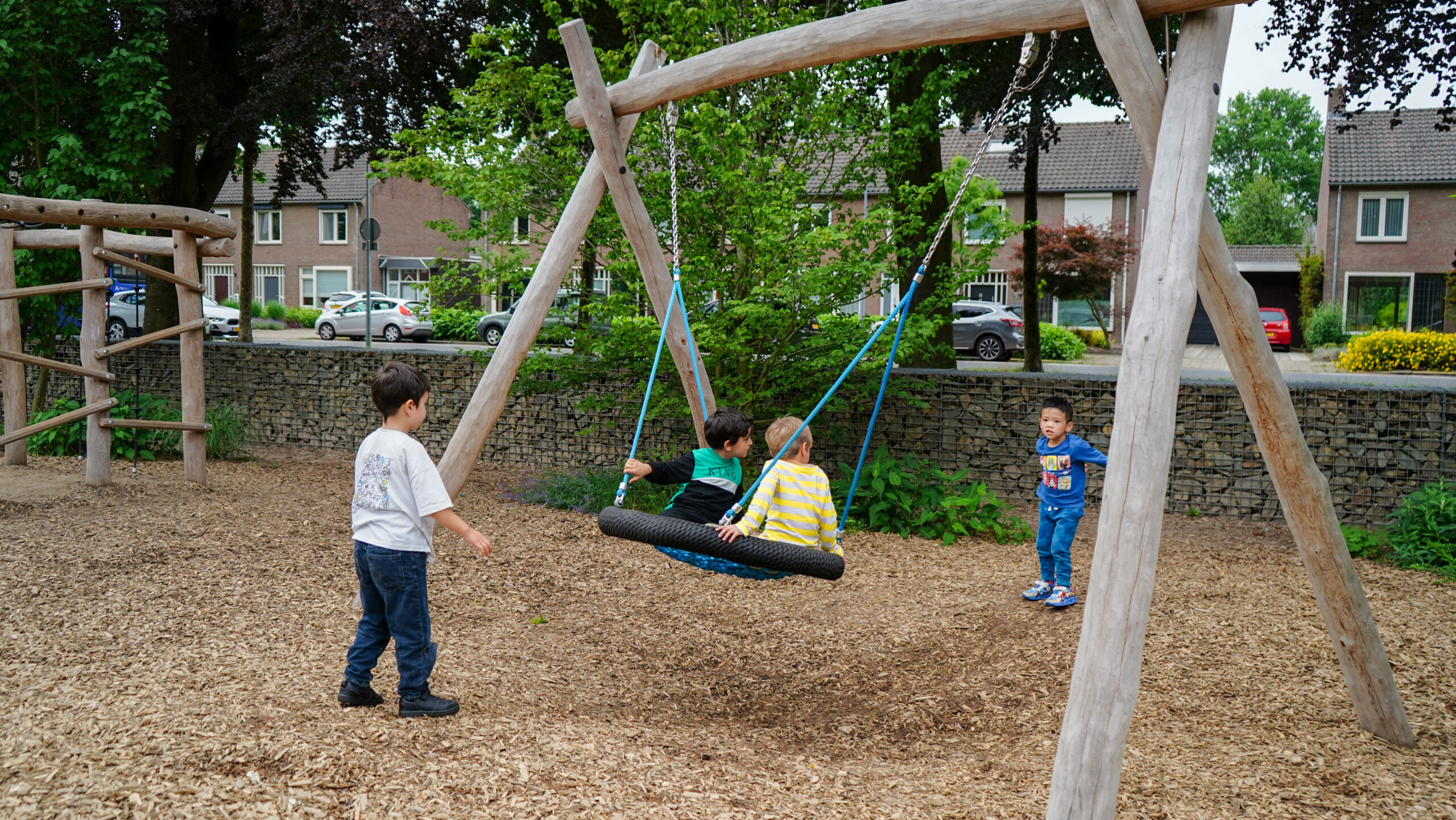 Aan de Bron Weert Kinderen spelen samen met een netschommel op een groen schoolplein