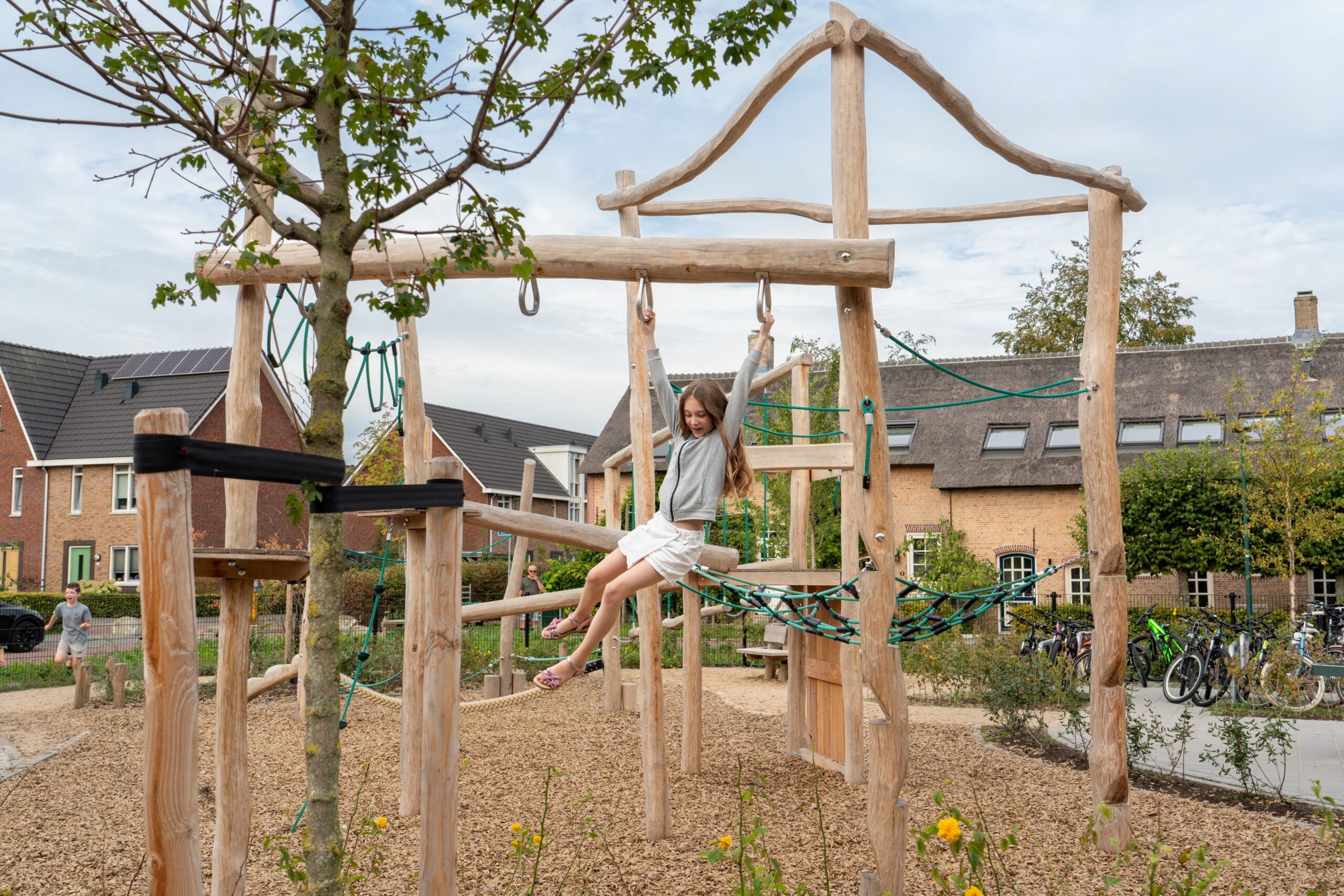 Basisschool Heilig Hart Dongen Kind speelt op robina houten balanceer en klim toestel op schoolplein basisschool Heilig Hart