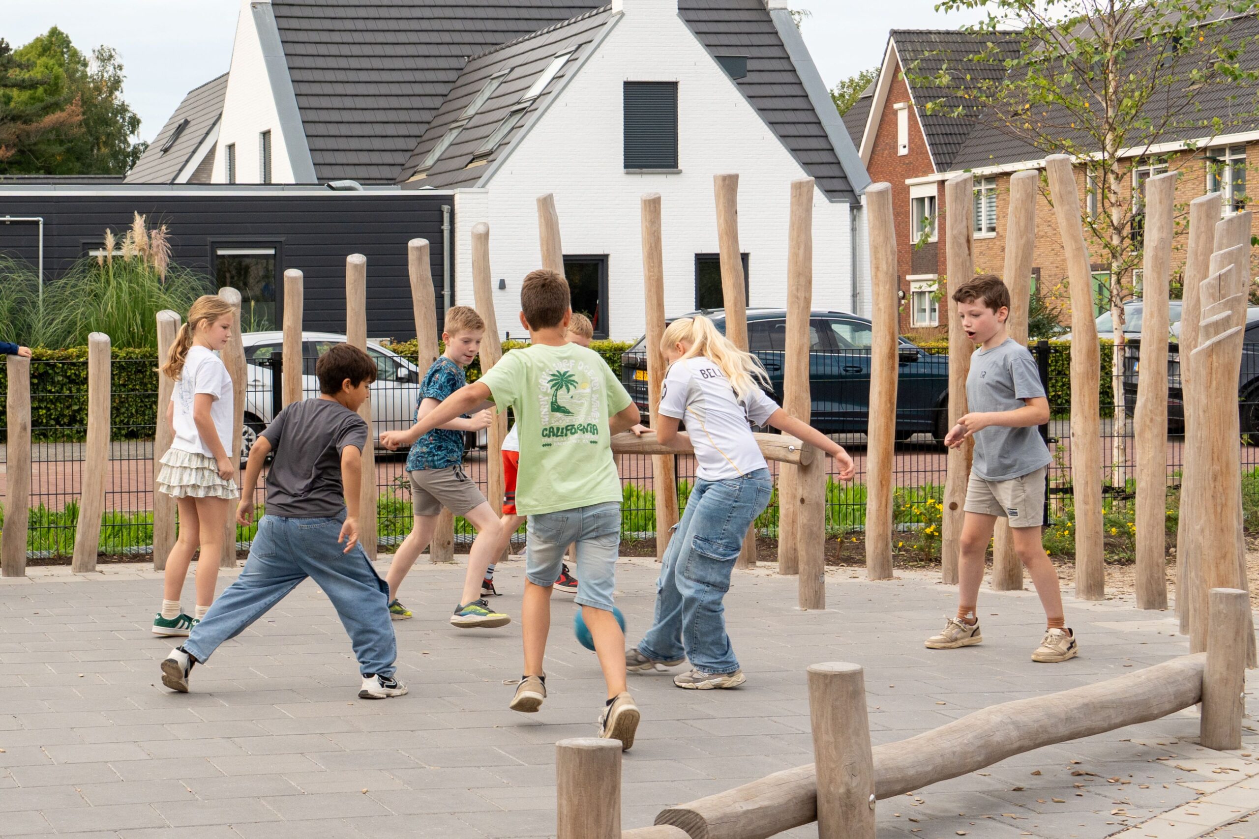 Basisschool Heilig Hart Dongen Kinderen voetballen samen op voetbalveldje met robina houten palen op schoolplein
