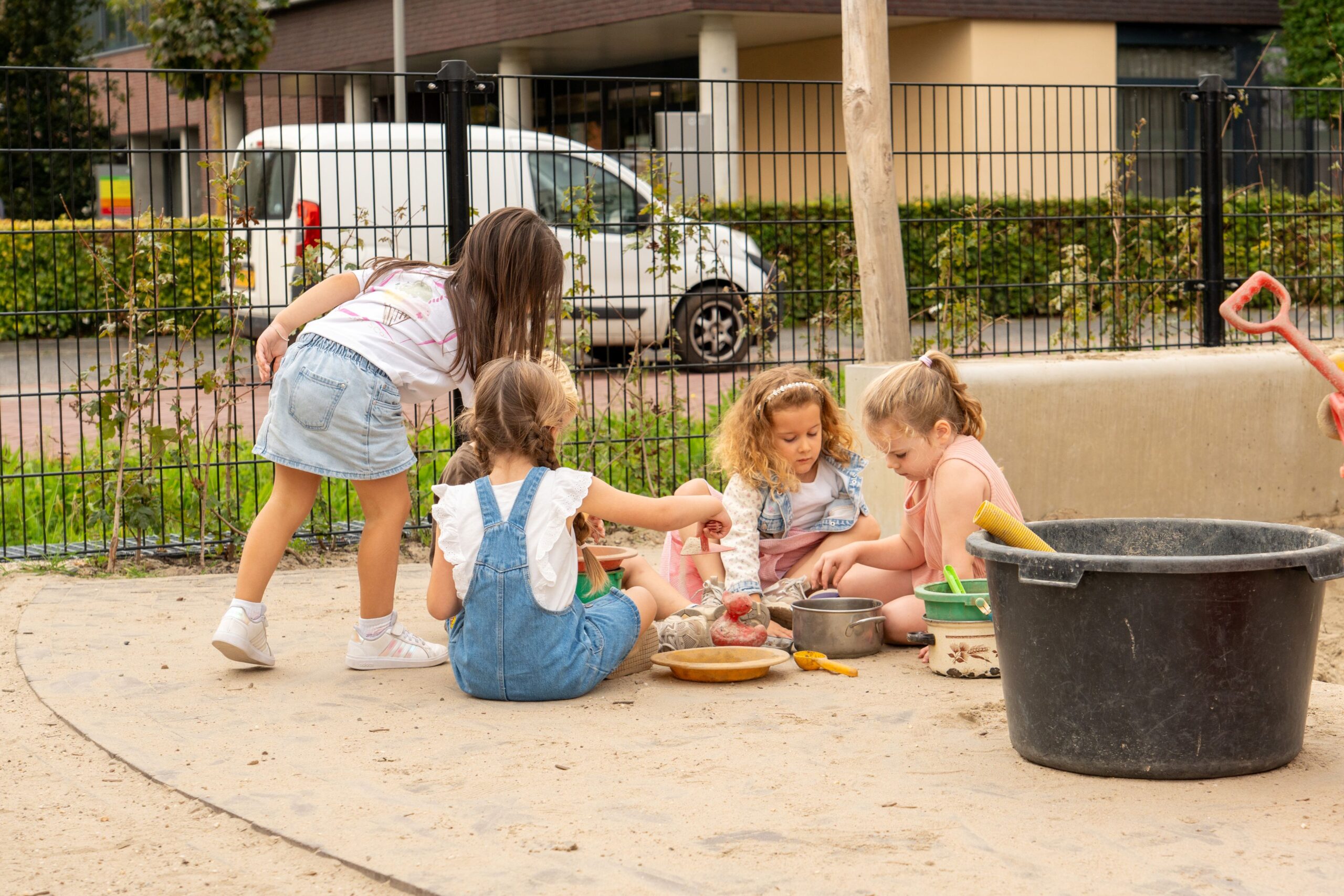 Basisschool Heilig Hart Dongen Kinderen spelen samen bij zandbak op groenblauw schoolplein Heilig Hart Dongen